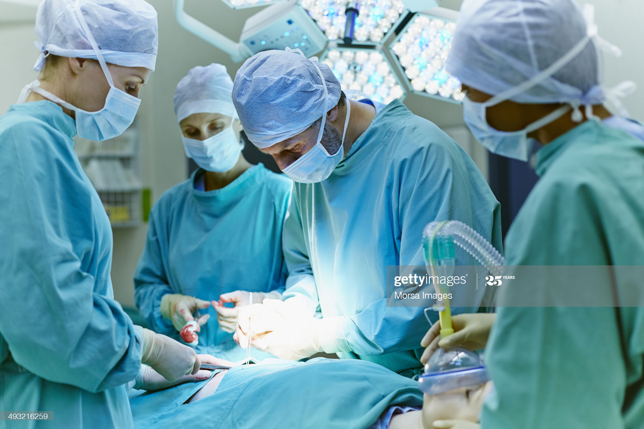 Group of surgeons performing surgery on patient in operating room